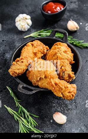 Würzige tiefgebratene panierte Hähnchendrumsticks. Schwarzer Hintergrund. Draufsicht Stockfoto