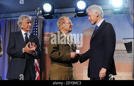 Kriegsveteran Scottie Ooton (3. L), der zur Befreiung eines Konzentrationslagers und Holocaust-Überlebenden und Autor Elie Wiesel (2. L) beitrug Werden mit Pins als Moderatoren Ex-Präsident Bill Clinton (R) Blick auf während der 20th Jahrestag National Tribute im United States Holocaust Memorial Museum 29. April 2013 in Washington, DC. Das Museum war Gastgeber einer zweitägigen Tribute-Veranstaltung zu Ehren von Holocaust-Überlebenden und Veteranen des Zweiten Weltkriegs zu seinem 20. Jahrestag. Foto von Olivier Douliery/ABACAUSA.com Stockfoto