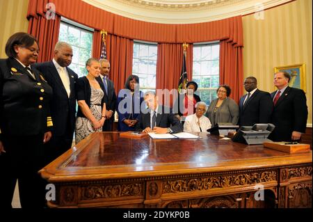 US-Präsident Barack Obama unterzeichnet eine Gesetzesvorlage im Oval Office, 24. Mai 2013 in Washington, DC, USA, mit der die Goldmedaille des Kongresses zum Gedenken an die vier jungen Mädchen, die bei den Bombenanschlägen der 16th Street Baptist Church 1963 in Birmingham, Alabama, getötet wurden, bezeichnet wird. Zeuge (L-R) Chirurg General Regina Benjamin, Birmingham Bürgermeister William Bell, Dr. Sharon Malone Holder, Generalstaatsanwalt Eric Holder, Rep Terri Sewell (D-AL), Thelma Pippen McNair (Mutter von Denise McNair), Lisa McNair (Schwester von Denise McNair), Dianne Braddock (Schwester von Carole Robertson), Rev Arthur Price, Jr (Pastor 16th Stree Stockfoto