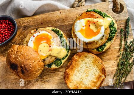 Gesunder, frischer Fisch-Burger mit Fischfilet, Spinat und Ei. Grauer Hintergrund. Draufsicht Stockfoto