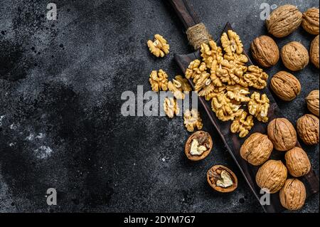 Geschälte Walnüsse Kerne auf Holz Schneidebrett. Schwarzer Hintergrund. Draufsicht. Speicherplatz kopieren Stockfoto