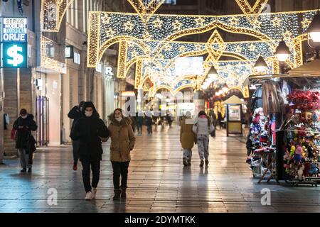 BELGRAD, SERBIEN - 3. DEZEMBER 2020: Junge Leute, ein Paar, die in den Straßen von Kneza Mihailova auf der Korona gehen und die Hände in einer Gesichtsmaske halten Stockfoto