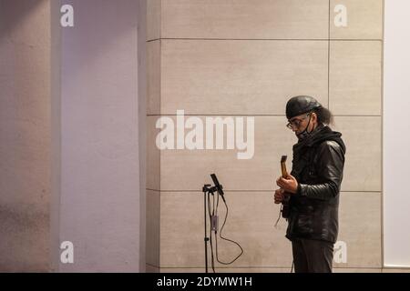 BELGRAD, SERBIEN - 15. DEZEMBER 2020: Straßenmusiker, ein Gitarrist, der in den Straßen Belgrads eine Atemmaske trägt Stockfoto