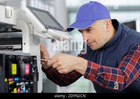 Ein Mann, der Fotokopierer repariert Stockfoto