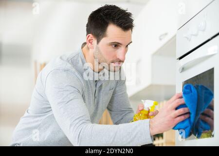 Mann Reinigung Ofen zu Hause Stockfoto