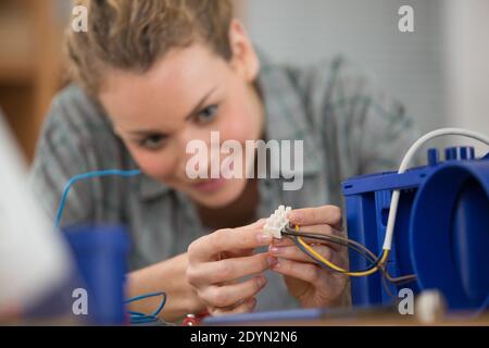 Frau in Elektronik-Werkstatt verbinden Draht Stockfoto