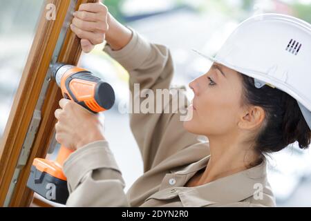 Fremdfirma mit Bohrer am Fenster Stockfoto