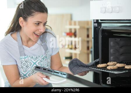 Junge Hausfrau macht hausgemachte Kekse in der Küche Stockfoto