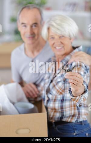 Ältere Paar zeigt Hausschlüssel Lichteffekt Stockfoto