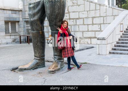 Eine weibliche junge iranische Touristen stehende Statue der Beine des Schahs in Sa'dabad Palastkomplex, von den Qajar und Pahlavi Monarchen gebaut Stockfoto