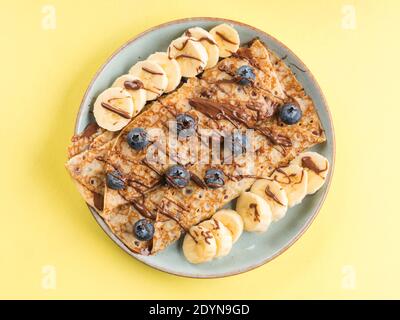 Crepes mit Schokoladennussaufstrich, Banane, Beeren Stockfoto