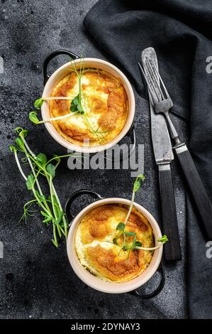 Spanische Omelette Tortilla in Pfanne serviert. Schwarzer Hintergrund. Draufsicht Stockfoto