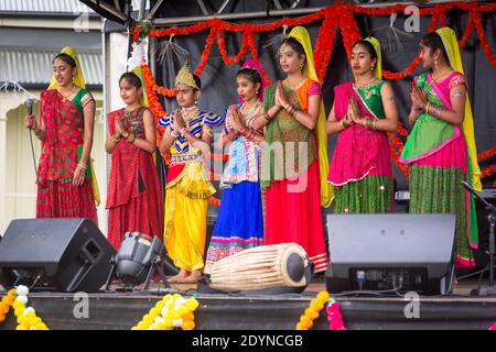 Eine Reihe von indischen Frauen in bunten Saris machen die namaste Geste. Fotografiert auf Diwali Festival Feiern Stockfoto