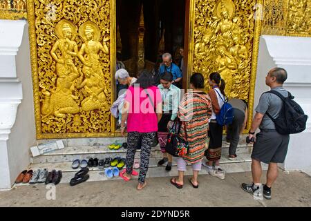 Touristen am Eingang zum Haus der königlichen Beerdigung Chariot, Wat Xieng Thong Tempel, Luang Prabang, Laos Stockfoto