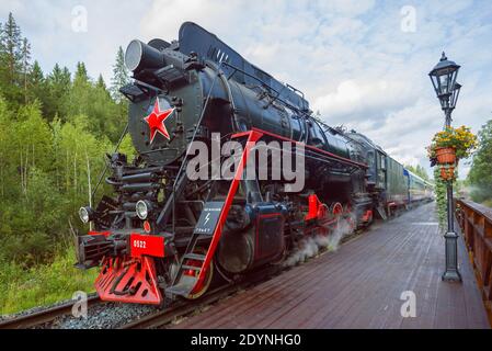 RUSKEALA, RUSSLAND - 15. AUGUST 2020: Sowjetische Dampflokomotive der Baureihe L mit dem Touristenzug Ruskeala Express auf dem Bahnsteig des Ruskeal Stockfoto