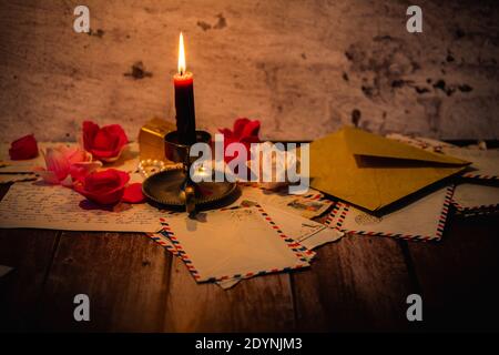 Viele alte und romantische Briefe auf Holzgrund beleuchtet Kerze Stockfoto