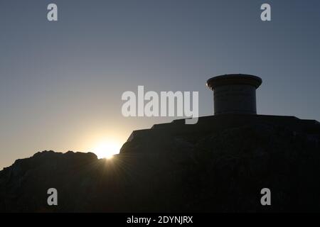 1 - Nahaufnahme des malvern Hills Beacon Toposcope bei Sonnenaufgang. Ein Steindenkmal als Teil des Diamantenjubiläums im Silhouettenprofil. Der Himmel ist einfach. Stockfoto