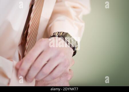 Der Mann knöpft die Ärmel seines Hemdes. Stockfoto