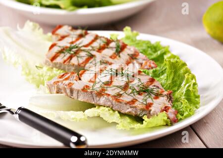 Gegrillter Thunfisch mit Salat auf einem Teller bereit zum Essen. Stockfoto