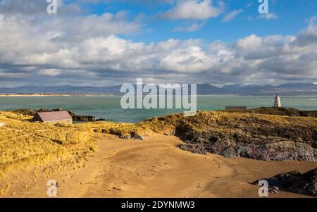 Ein Blick auf Twr Bach und die schneebedeckten Snowdonia Berge von Llanddwyn Insel, Anglesey Stockfoto