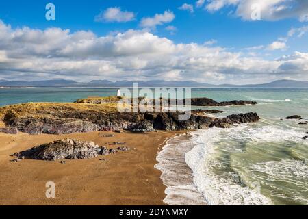 Ein Blick auf Twr Bach und die schneebedeckten Snowdonia Berge über Porth Twr Mawr auf Llanddwyn Island, Anglesey Stockfoto