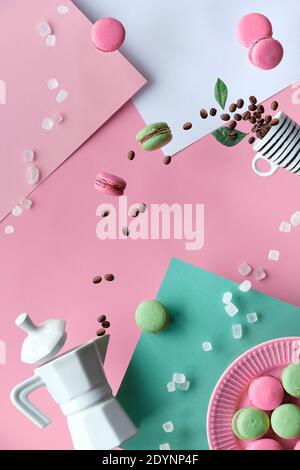 Levitation und Balance Zusammensetzung. Fliegende Makronen, Keramik-Kaffeemaschine, Espresso-Kaffeetasse. Geometrisch geschichteten Papier Hintergrund in rosa und mint g Stockfoto