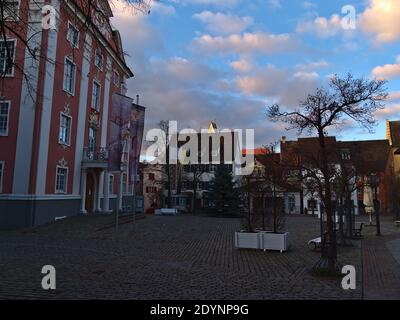 Leerer Stadtplatz Schlossplatz vor dem historischen Gebäude Neues Schloss (neues Schloss, heute Museum) mit rosa Fassade in der Wintersaison. Stockfoto