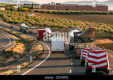 Spezieller Transport von Rotorblättern für Windenergieanlagen. Mehrere LKW mit Windturbinenblättern auf der Autobahn mit Beacon Fahrzeuge hinter anderen warnen Stockfoto