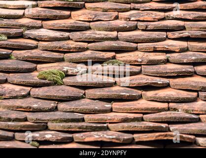 Nahaufnahme Detail mit den roten Steinfliesen eines Daches. Stockfoto
