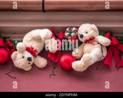 Weihnachtsschmuck mit roten Globen und Teddybären auf einem Gebäudewand Stockfoto