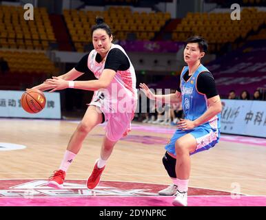 (201227) -- BENGBU, 27. Dezember 2020 (Xinhua) -- Xu Chenyan (L) aus dem Jiangsu-Team spielt mit Tang Yu aus Peking beim Viertelfinale zwischen dem Jiangsu-Team und dem Pekinger Team in der Saison 2020-2021 der Liga der Women's Chinese Basketball Association (WCBA) in Bengbu in der ostchinesischen Provinz Anhui, 27. Dezember 2020. (Xinhua/Zhou Mu) Stockfoto
