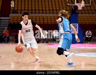(201227) -- BENGBU, 27. Dezember 2020 (Xinhua) -- Jin Weina (L) aus dem Jiangsu-Team dribbelt während des Viertelfinalmatches zwischen dem Jiangsu-Team und dem Pekinger Team bei der Saison 2020-2021 Women's Chinese Basketball Association (WCBA) Liga in Bengbu in der ostchinesischen Provinz Anhui, 27. Dezember 2020. (Xinhua/Zhou Mu) Stockfoto