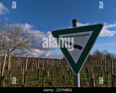 Grün und weiß gefärbtes Metallschild in dreieckiger Form mit schwarz bemalten Greifvogel, der Wanderer darüber informiert, dass sie eine Landschaft geschützten Bereich betreten. Stockfoto