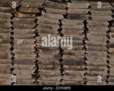 Nahaufnahme des verwitterten Stapels von gestapelten Holzplanken mit Holzstruktur. Stockfoto