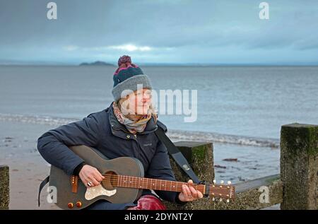 Portobello, Edinburgh, Schottland, Großbritannien. 27 Dezember 2020. Rosie Nimmo chillen an den Groynes am Meer während dieser schwierigen Zeiten von Covid -19 Lockdown findet sie den Strand gibt ihre Inspiration und hilft ihr zu entspannen. Rosie ist eine Edinburgher Sängerin und Songwriterin, die auch in einer Jazz/Blues Band auftritt. Ihr neues Album, Where Time Suspending, ist fertig und wartet auf die Veröffentlichung am 5. Februar 2021. Ihre ersten drei Alben, Lazy and Mellow, Home und Scrapbook, alle gingen auf viele glühende Rezensionen zu sammeln und von verschiedenen Radiosendungen gespielt werden, einschließlich BBC Radio Scotland Iain Anderson Credit: Arch White/ Stockfoto