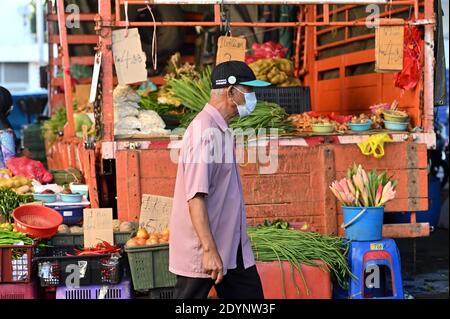 Kuala Lumpur, Malaysia. Dezember 2020. Ein Mann trägt Gesichtsmaske Geschäfte auf einem Markt in Kuala Lumpur, Malaysia, 27. Dezember 2020. Malaysia meldete 1,196 neue COVID-19-Infektionen, teilte das Gesundheitsministerium am Sonntag mit und brachte die nationale Gesamtzahl auf 105,096. Quelle: Chong Voon Chung/Xinhua/Alamy Live News Stockfoto