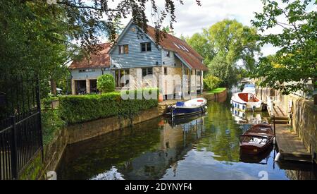 River Front Grundstück auf Stelzen mit Wasser und Boote im Vordergrund. Stockfoto