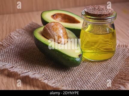 Avocado und Avocado-Öl auf Holzgrund. Selektiver Fokus Stockfoto