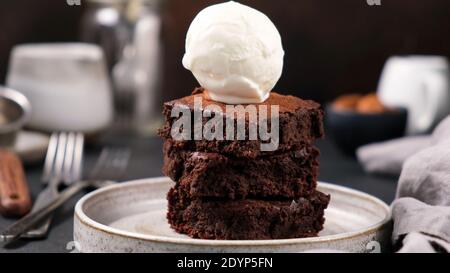 Schokoladen-Brownies mit Vanille-Eislöffel auf der Oberseite. Süßes, reichhaltiges Dessert Stockfoto