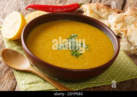 Rote Linsenpüree-Suppe mit Brot und Zitrone in einer Schüssel auf dem Tisch serviert. Horizontal Stockfoto