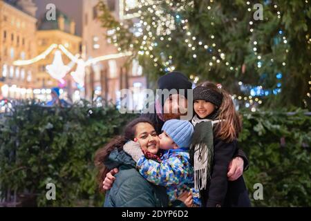 Glückliche multinationale Familie im Freien in einer Innenstadt zu Weihnachten Stockfoto