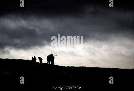 Wanderer auf Bleaklow Moor im Peak District von Derbyshire, nach Tagen von nassem und winterlichem Wetter während der Weihnachtspause, mit einem kalten Snap und eisigen Bedingungen noch kommen. Stockfoto