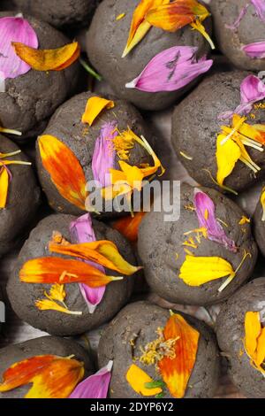 Hausgemachte Blumenbomben, oder Samenkugeln, mit Lehmboden mit verschiedenen Blumensamen eingebettet und mit Blütenblättern verziert gemacht. VEREINIGTES KÖNIGREICH Stockfoto