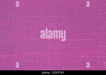 Violetter Hintergrund von alter abblätternder Farbe mit Rissen. Stockfoto