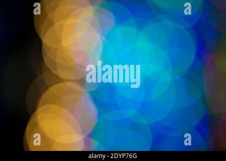 Mehrfarbige große Bokeh-Flecken in blau und gelb. Bokeh aus einer Weihnachtsgirlande. Stockfoto