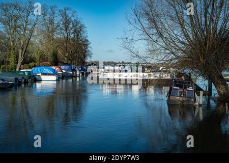 Oxford, Oxfordshire, Großbritannien. 27. Dezember 2020. Boote, die auf dem BosumÕs Boatyard festgemacht sind, müssen vorsichtig sein, wenn Wasser aufsteigt. Überschwemmungen in Oxfordshire. Sturm Bella brachte noch mehr Regen nach Oxford und verursachte Überschwemmungen in tief liegenden Gebieten. Viele Menschen sind aus der Ausübung in der Sonne. Kredit: Sidney Bruere/Alamy Live Nachrichten Stockfoto