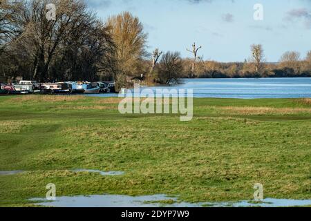 Oxford, Oxfordshire, Großbritannien. 27. Dezember 2020. Oxford Bewohner gehen in Port Meadow, um die steigenden Gewässer zu untersuchen. Überschwemmungen in Oxfordshire. Sturm Bella brachte noch mehr Regen nach Oxford und verursachte Überschwemmungen in tief liegenden Gebieten. Viele Menschen sind aus der Ausübung in der Sonne. Kredit: Sidney Bruere/Alamy Live Nachrichten Stockfoto