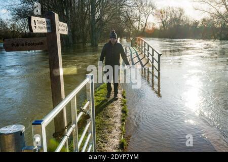 Oxford, Oxfordshire, Großbritannien. 27. Dezember 2020. Ein Mann erkundet die Themse. Die Fußgängerbrücke auf dem Themse-Pfad in Oxford ist überflutet. Überschwemmungen in Oxfordshire. Sturm Bella brachte noch mehr Regen nach Oxford und verursachte Überschwemmungen in tief liegenden Gebieten. Viele Menschen sind aus der Ausübung in der Sonne. Kredit: Sidney Bruere/Alamy Live Nachrichten Stockfoto