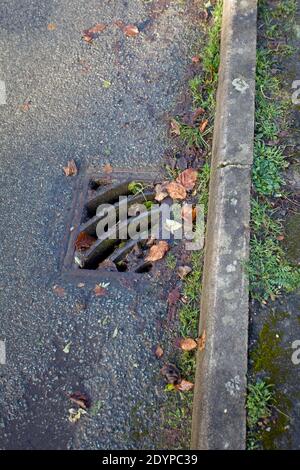 Ablassabdeckung aus Gusseisen auf der Straße. England Stockfoto