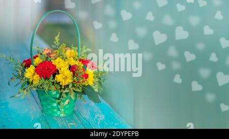 Schöne Rosen in einem Korb auf einem Holztisch, eine Kopie des Raumes, Bokeh in Form von Herzen. Stockfoto